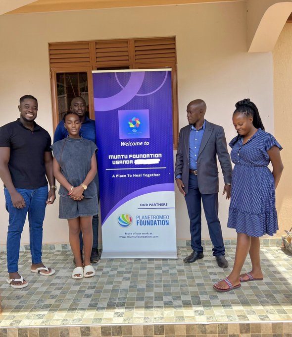 Team members beside the Muntu Foundation banner