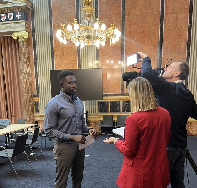 A person being interviewed by a film crew at a conference