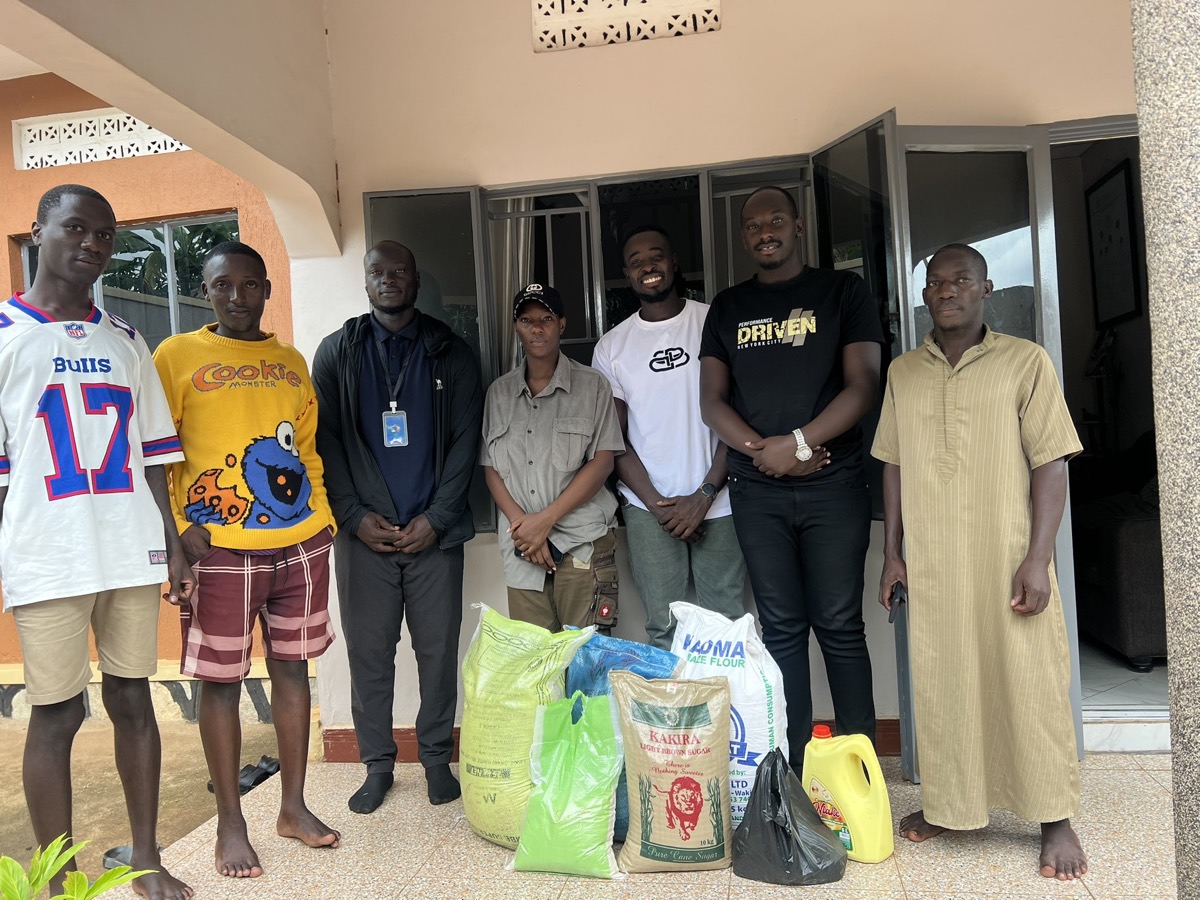 A group beside sacks of food and supplies at a distribution